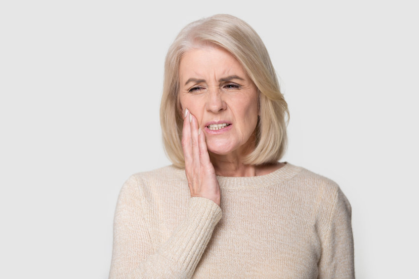 Headshot of a woman touching cheek suffers from toothache